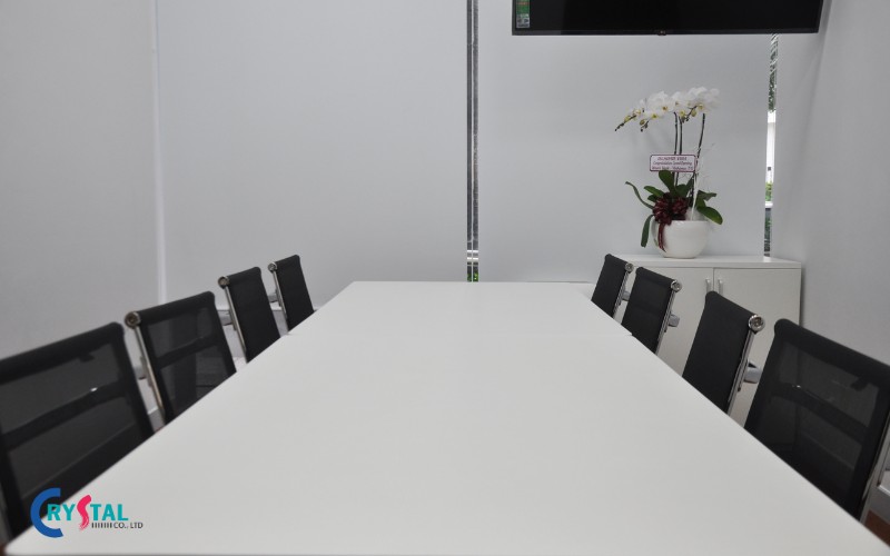 Phòng họp rộng rãi với bàn trắng tươi mới, trẻ trung, ghế đen tương phản làm điểm nhấn 