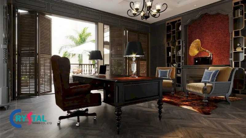 Văn phòng Indochine sang trọng, bàn làm việc gỗ tối màu, ghế da nâu cao cấp và cửa chớp gỗ nhìn ra không gian xanh mát.