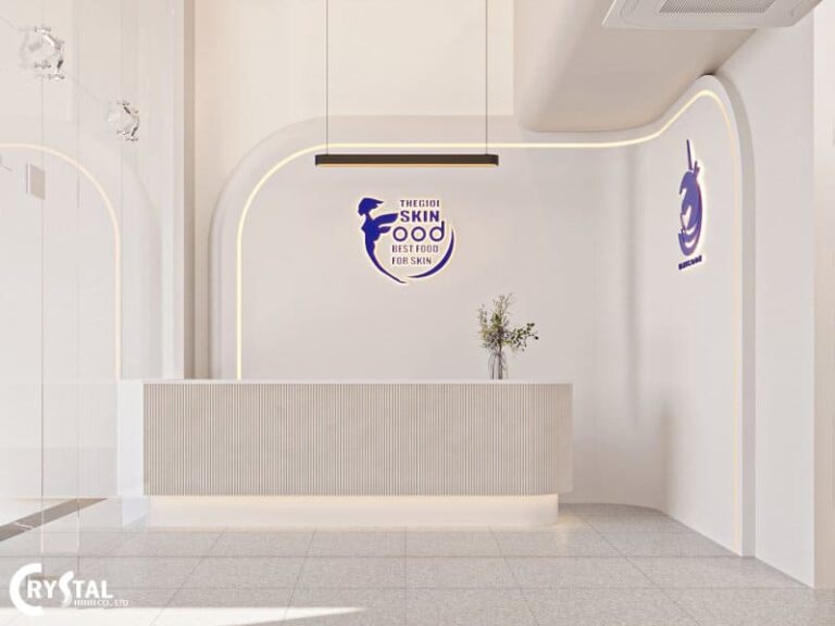 Quầy lễ tân sang trọng, thiết kế màu trắng tinh tế, logo xanh dương, không gian làm việc hiện đại.