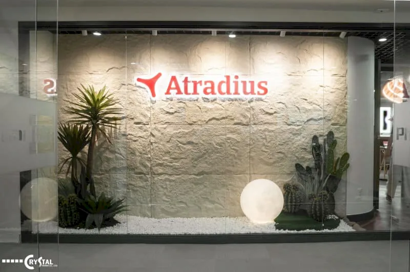Khu vực sảnh Atradius nổi bật với logo đỏ, nền tường đá và tiểu cảnh cây xanh trang trí.