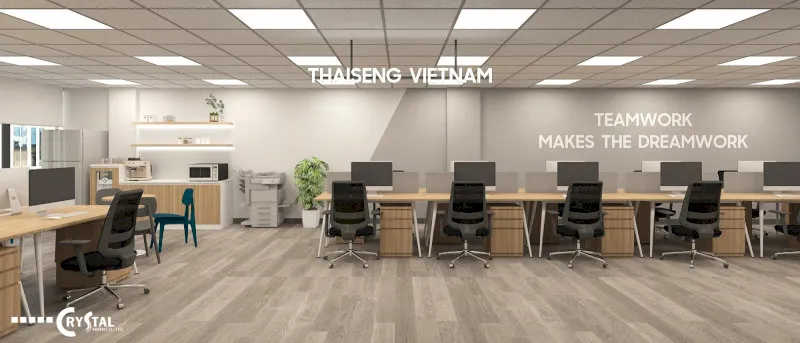 Văn phòng làm việc hiện đại của Thaiseng Vietnam với bàn dài màu be, ghế xoay đen, sàn gỗ sáng và khẩu hiệu "Teamwork makes the dreamwork" trên tường.