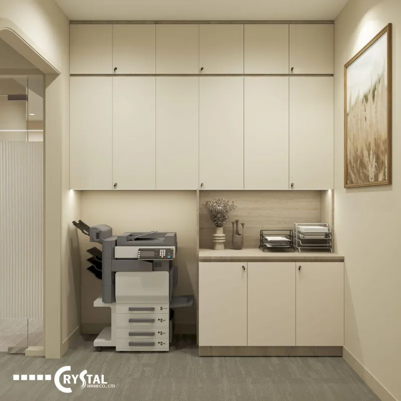 Góc văn phòng với tủ tài liệu cao màu kem, máy in đa năng, kệ để tài liệu và tranh treo tường đơn giản.