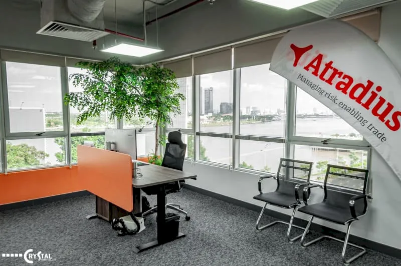 Góc văn phòng hiện đại với bàn làm việc đơn, ghế chờ và không gian tràn ngập ánh sáng tự nhiên.
