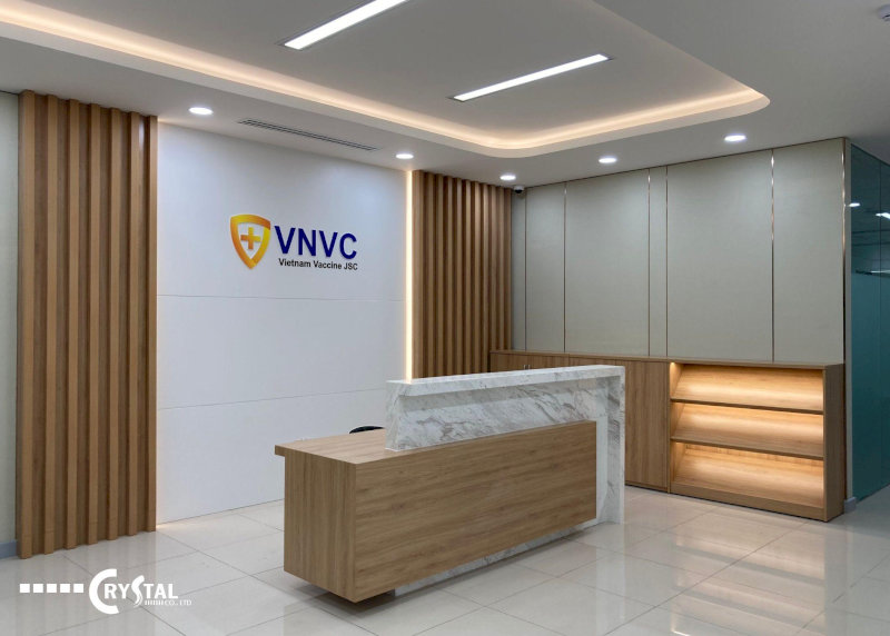 Quầy lễ tân hiện đại với thiết kế gỗ và đá marble tại văn phòng VNVC Vietnam Vaccine JSC.