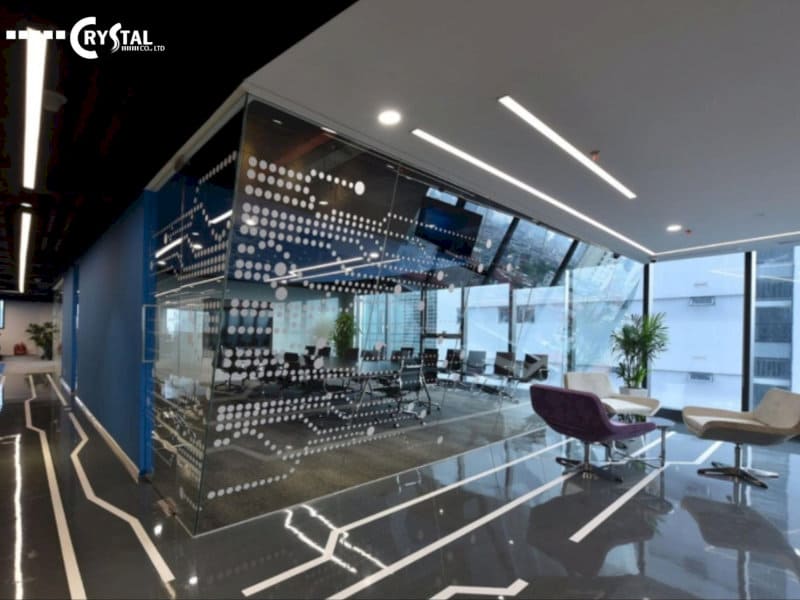 Không gian văn phòng hiện đại với vách kính trang trí họa tiết, logo CRYSTAL và nhiều cây xanh.