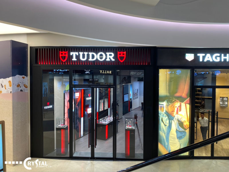 Showroom Tudor sang trọng, hiện đại với mặt tiền đen và logo đỏ nổi bật, trưng bày đồng hồ và phụ kiện cao cấp