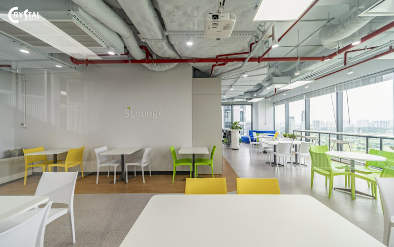 Chỗ nghỉ chân hiện đại, đẹp mắt với bàn ghế màu trắng, vàng, xanh lá cây và logo "sLounge" trên tường