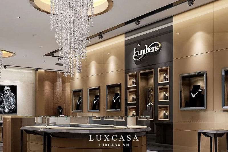 Showroom trang sức Lumbers cao cấp, sang trọng với tủ trưng bày đèn vàng, màn hình lớn và khu vực tiếp khách