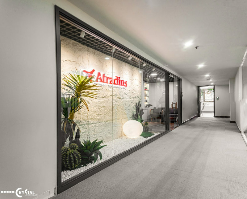 Văn phòng Atradius hiện đại với bức tường đá trang trí, cây xanh và logo nổi bật, tạo lối vào chuyên nghiệp