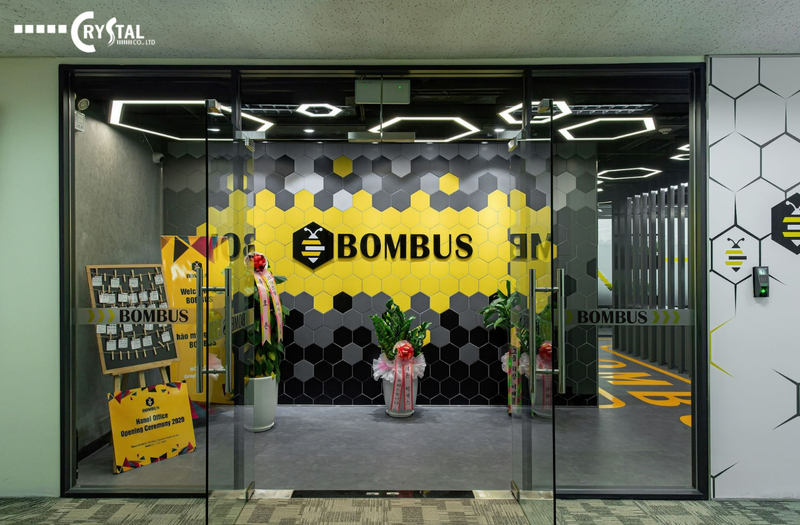 Lối vào văn phòng Bombus Hà Nội với thiết kế tổ ong màu vàng và đen độc đáo, cùng các biểu ngữ chào mừng