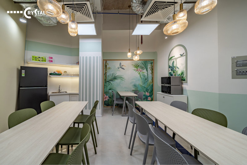 Khu vực pantry văn phòng thông minh với thiết kế tươi sáng, bàn ăn dài và tủ bếp tiện nghi