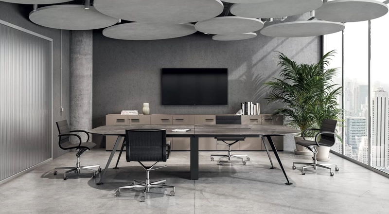 Phòng họp tối giản với bàn gỗ bo góc, ghế lưới mảnh, các tấm baffle treo trần và một chậu cây xanh duy nhất (Nguồn: Internet)