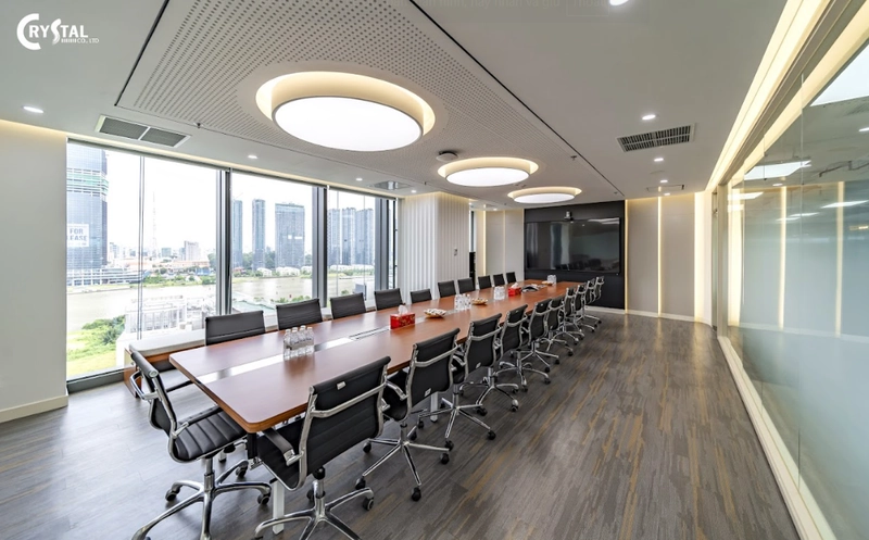 Phòng hợp của văn phòng lớn với bàn gỗ dài, ghế da cao cấp và hệ đèn ấn tượng (Nguồn: Deco Crystal)