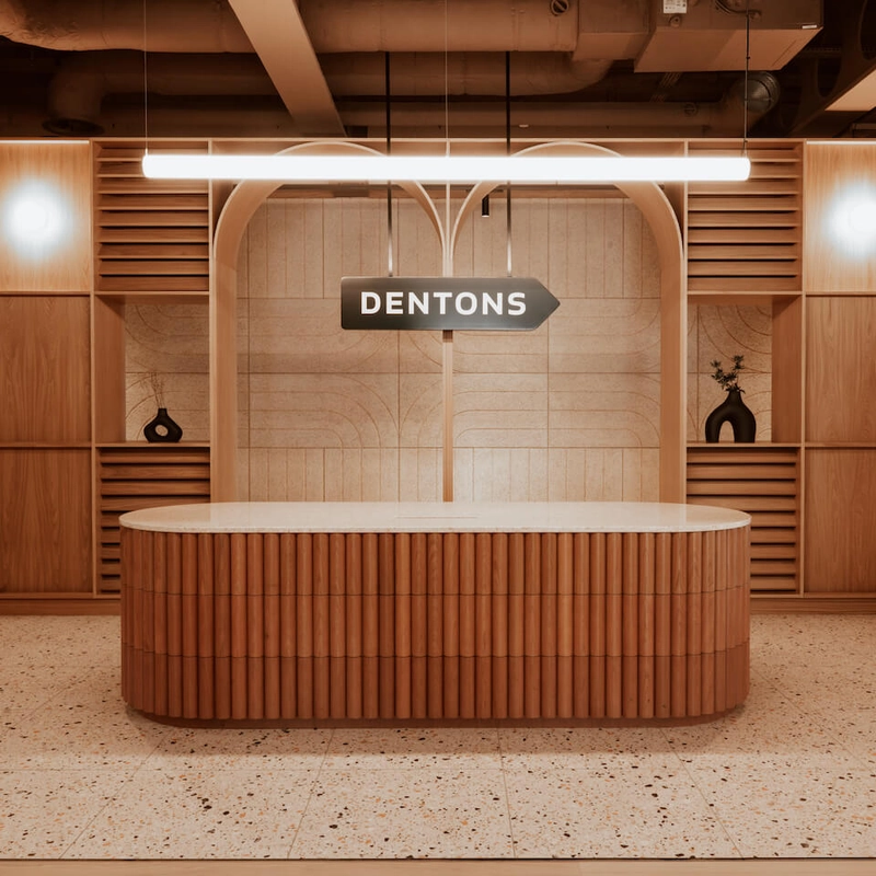 Quầy lễ tân bọc gỗ lượn sóng tinh tế sàn Terrazzo hiện đại và ánh sáng ấm áp, mang lại cảm giác thân thiện và cao cấp cho khách hàng (Nguồn: Internet)