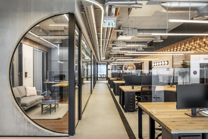 Intentionally exposed copper piping and copper-tinged Edison bulbs introduce rich warmth, softening the cold concrete shell of this modern tech lounge (Source: Internet) 