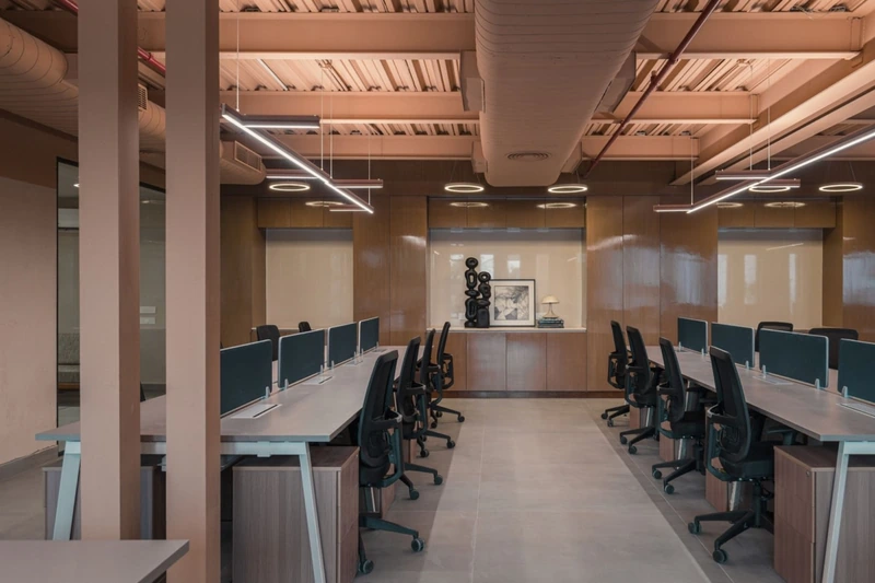 A workspace showcases custom furniture pieces, blending raw architectural steel with warm textured screens (Source: Internet) 