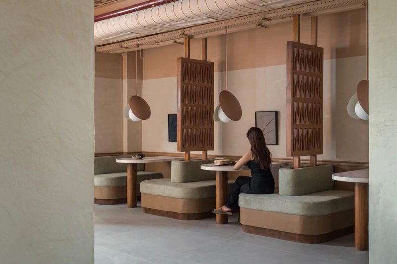 A workspace showcases custom furniture pieces, blending raw architectural steel with warm textured screens (Source: Internet)