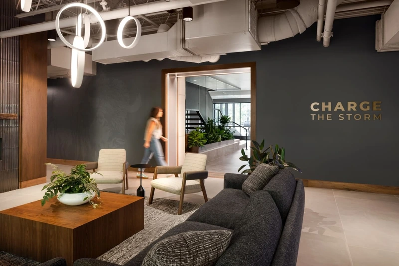 Oversized seating in rich natural textures and bespoke wood desks elevate this former industrial shell into a highly refined, professional executive environment (Source: Internet) 