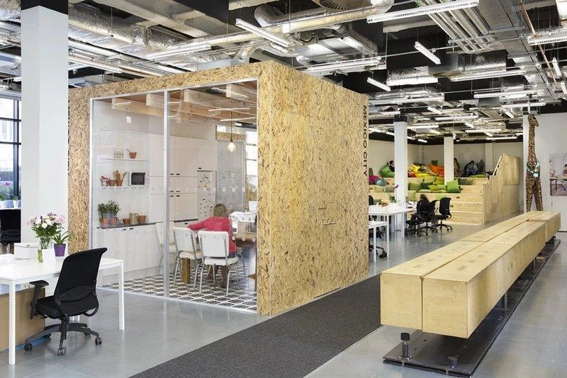 Phòng họp dạng hộp gỗ ép đặt giữa khu làm việc mở của một văn phòng 80m2 kiểu công nghiệp