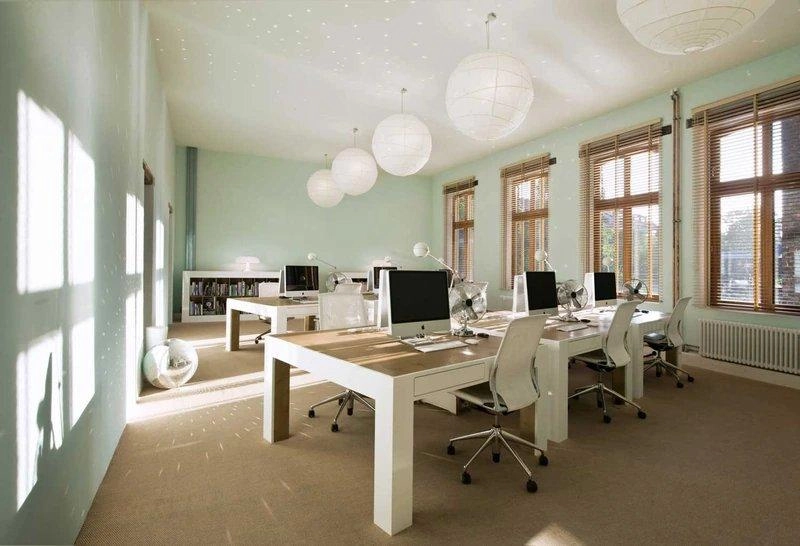 Tường xanh pastel, bàn trắng và cửa sổ lớn trong mẫu thiết kế văn phòng 80m2 bố cục mở