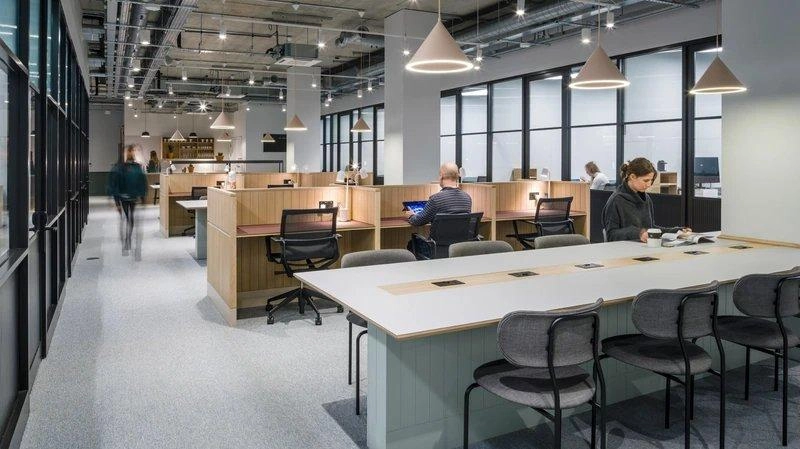 Trần mở kết hợp gỗ sáng màu và ghế ngồi dạng hốc trong mẫu thiết kế văn phòng 80m2 công nghiệp