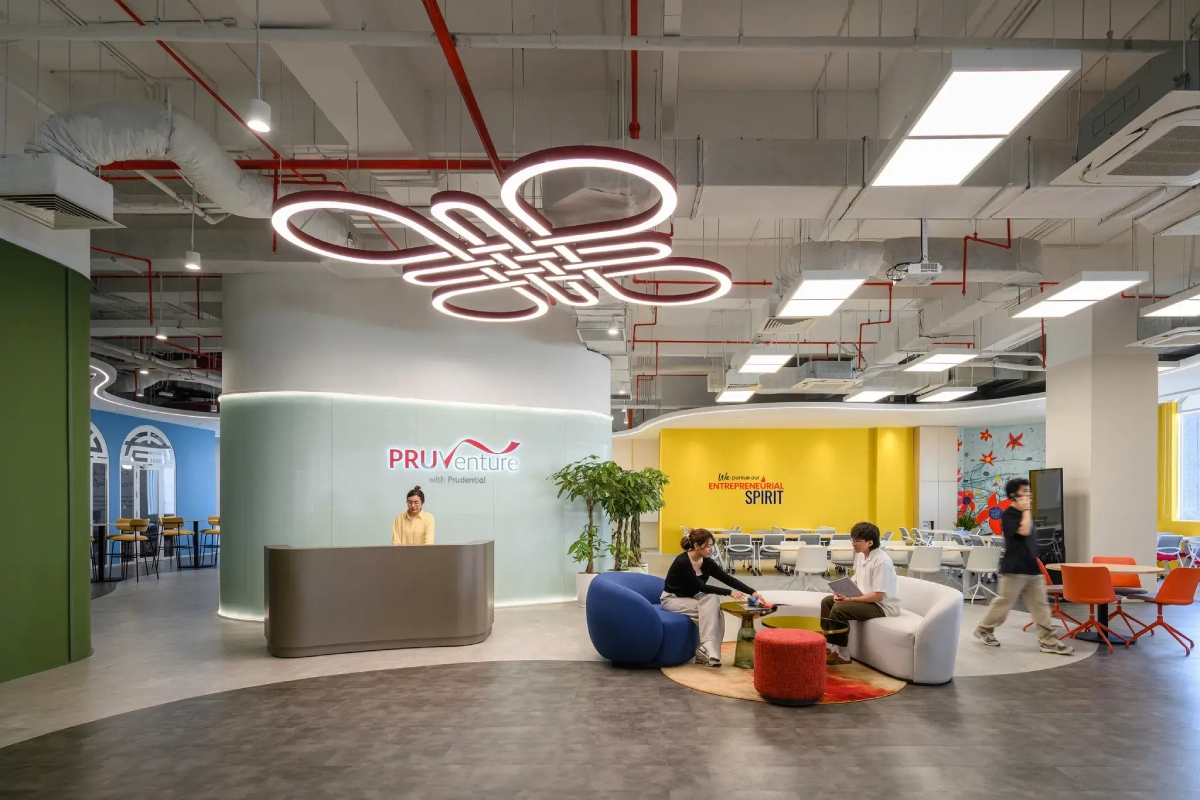 Văn phòng PRUVenture có đèn logo neon đỏ và sofa nhiều màu, tư vấn thi công nội thất văn phòng hiện đại