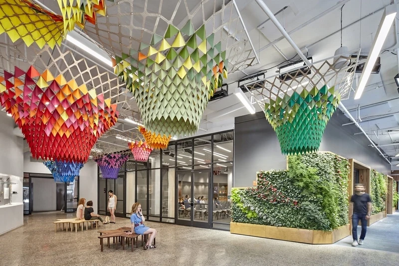 Colorful geometric canopies and expansive living green walls merge nature and art in this modern workspace.