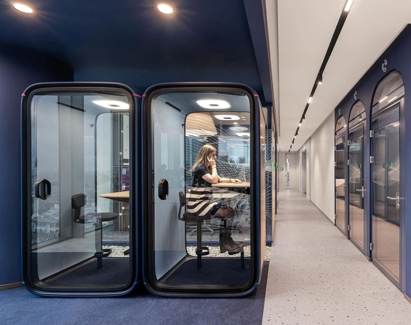 Private acoustic pod featuring high-density sound-absorbing upholstery for confidential calls and focused work