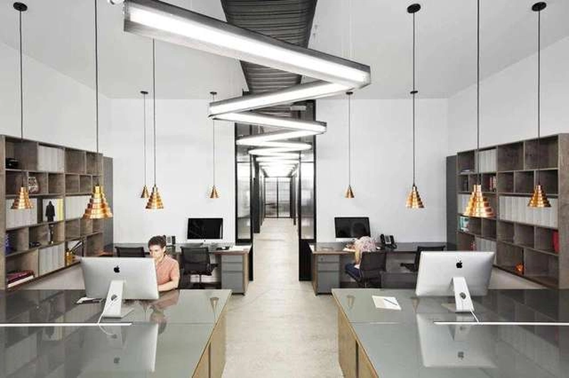 Hai dãy bàn đối xứng và kệ lưu trữ sát tường trong bố trí văn phòng 70m2 hiện đại